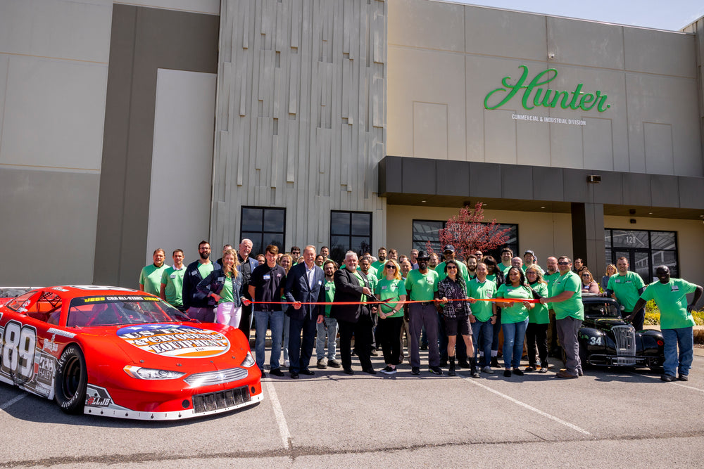 image of staff cutting ribbon in front of workplace building