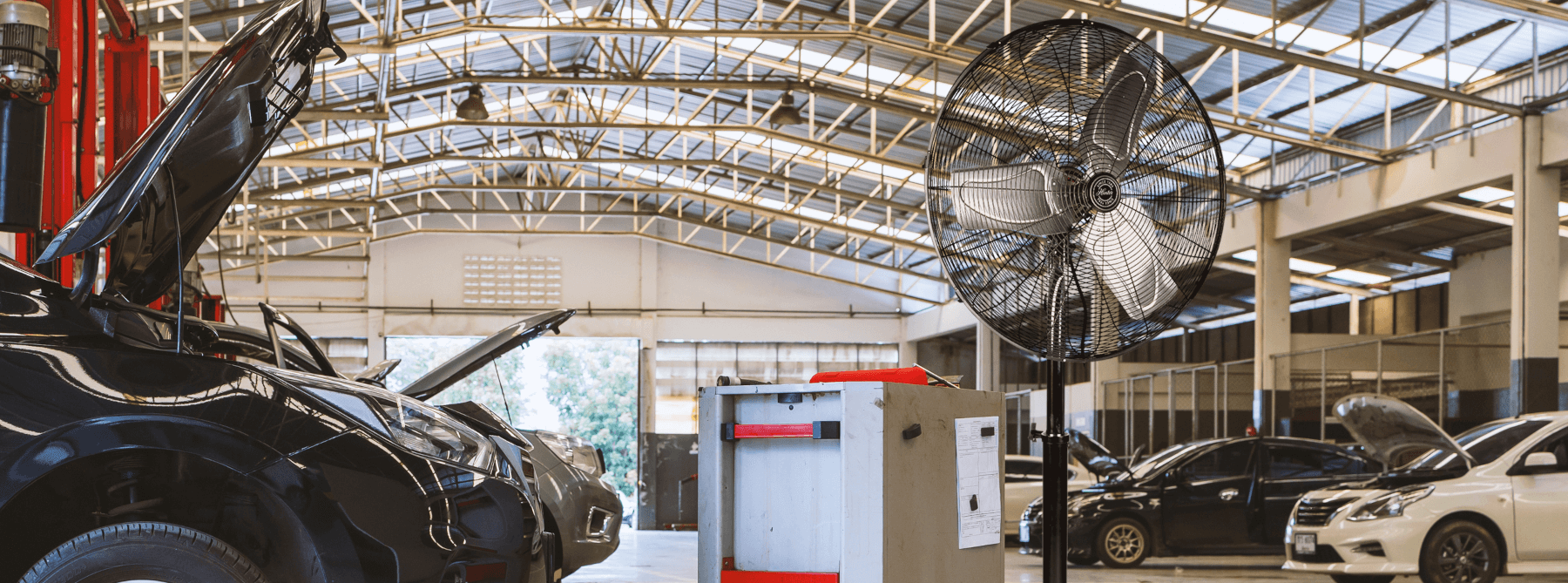 Close-up of a wall mount fan on a black background.