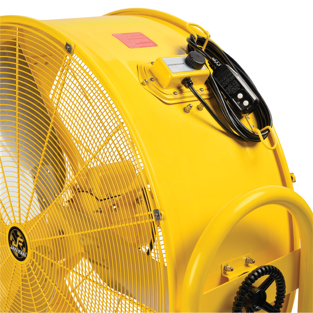 Close-up of a yellow Jan Fan industrial drum fan showing the metal grille, blades, and speed control with power cord.